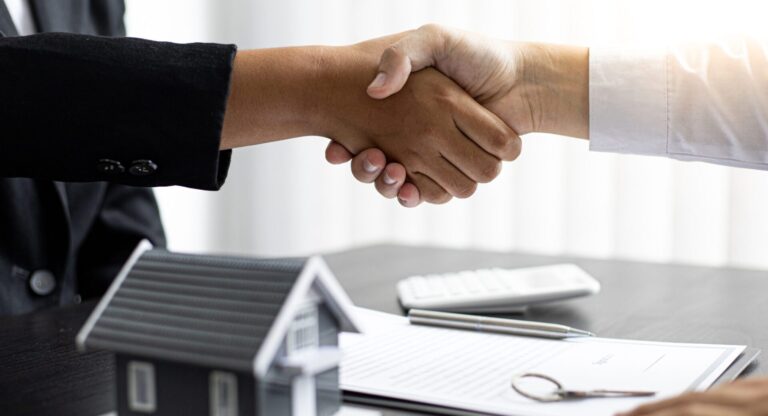 Handshake between homeowner and property developer over house sale contract