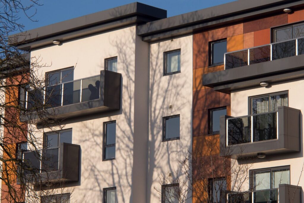 Contemporary apartment building with sleek balconies and clean architecture, ideal for property investors seeking flats for sale in urban or suburban areas.