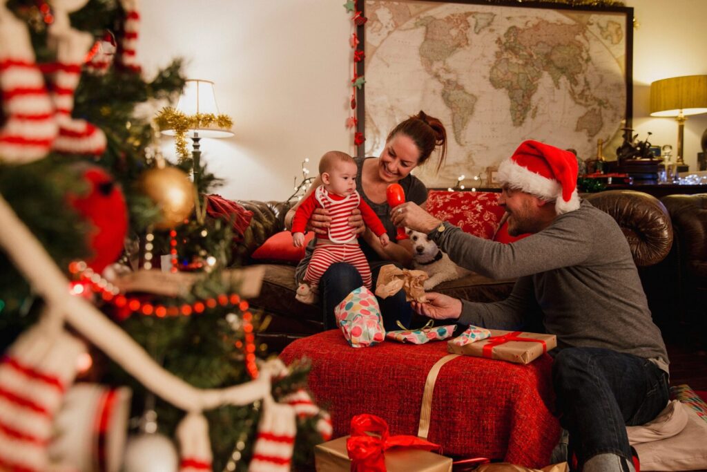 Family celebrating Christmas together at home in Sutton Coldfield, opening presents and enjoying festive decorations in a cosy living room