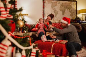 Family celebrating Christmas together at home in Sutton Coldfield, opening presents and enjoying festive decorations in a cosy living room