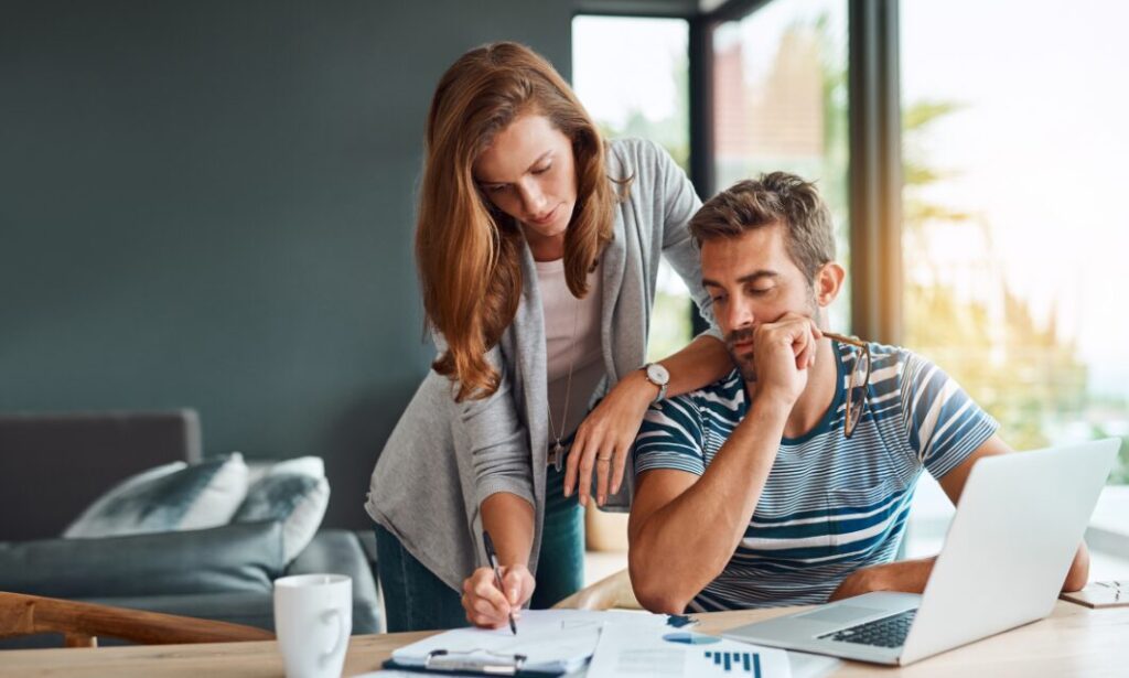 Couple reviewing documents at home with a laptop while planning for upcoming tenancy and legislation changes.