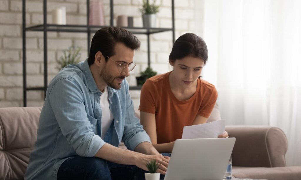 Landlord couple reviewing property compliance paperwork and online records at home ahead of the new Property Portal requirements
