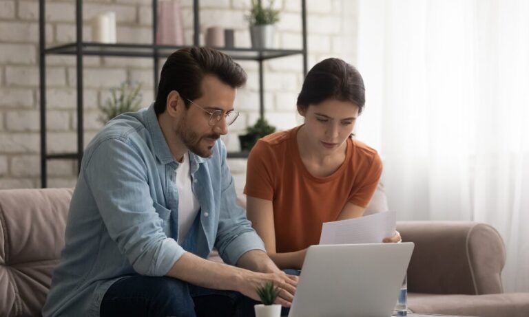 Landlord couple reviewing property compliance paperwork and online records at home ahead of the new Property Portal requirements
