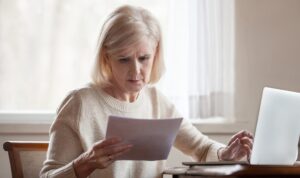 Landlord checking tenancy documents alongside rent records on a laptop