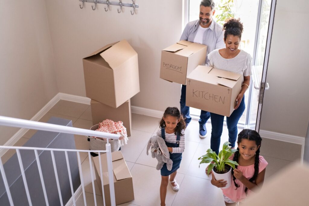 Young family moving into their first home in Stanmore, carrying boxes and settling into a starter property in North West London