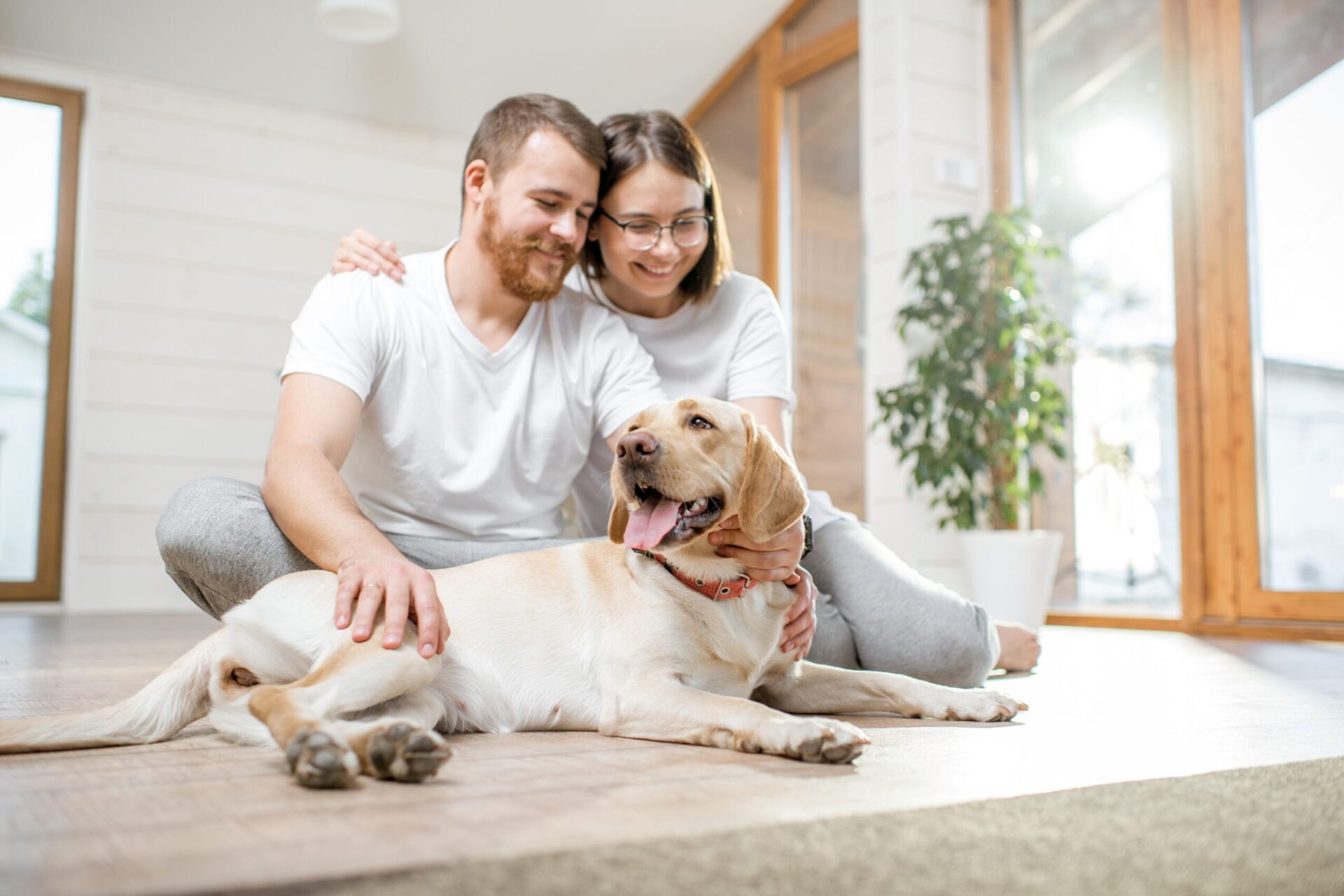 Couple sitting on the floor with their dog inside a pet-friendly rental property in Skipton