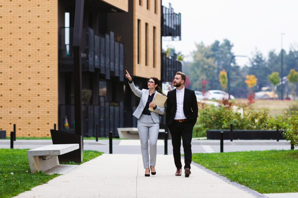 Property manager walking with a landlord outside a residential development while discussing tenancy law changes