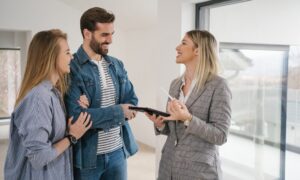 Lettings agent discussing a rental property with a couple during a viewing in Bridgend
