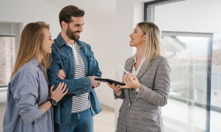 Lettings agent discussing a rental property with a couple during a viewing in Bridgend