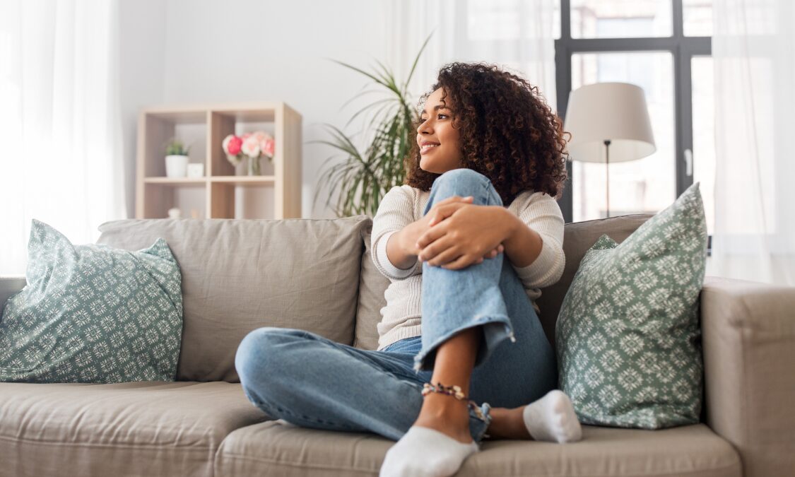 Woman relaxing in a modern living room, reflecting the lifestyle appeal of Harborne homes