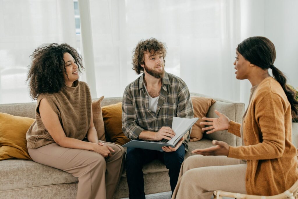 Property manager speaking with tenants in a living room about rental management and tenancy responsibilities