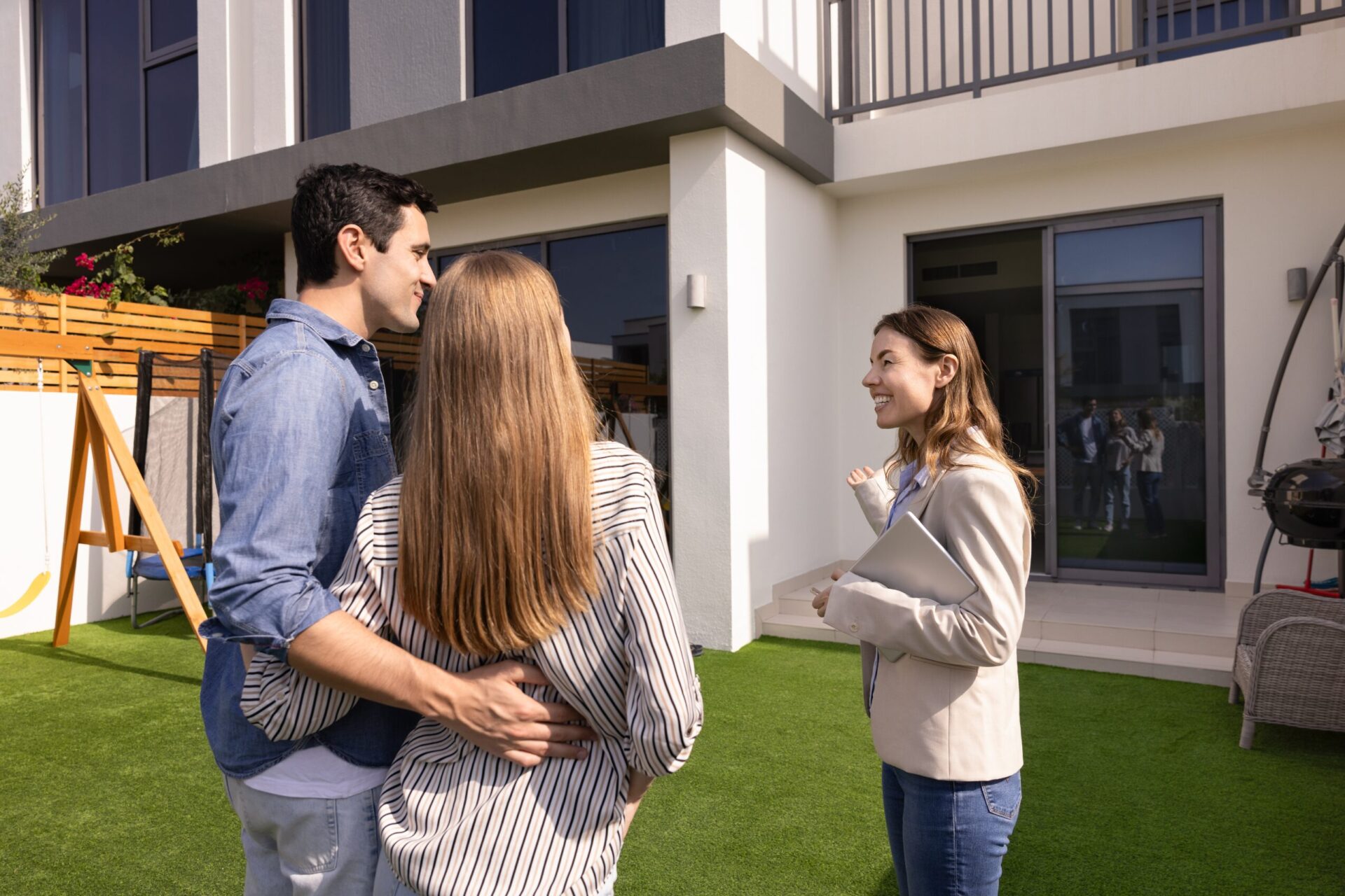 Estate agent discussing a property with buyers outside a modern home in Gravesend during a viewing