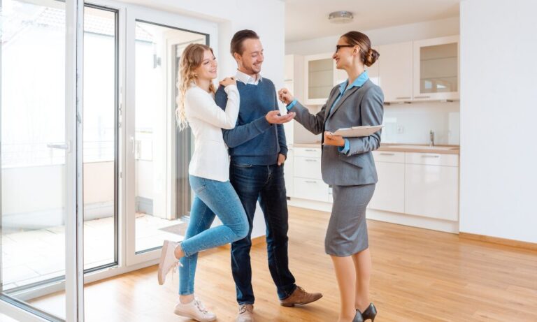 Estate agent handing keys to a couple inside a modern kitchen in Skipton
