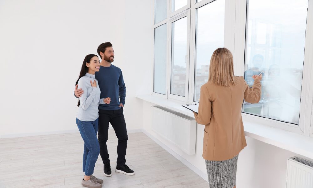 A letting agent showing a couple around an empty rental property
