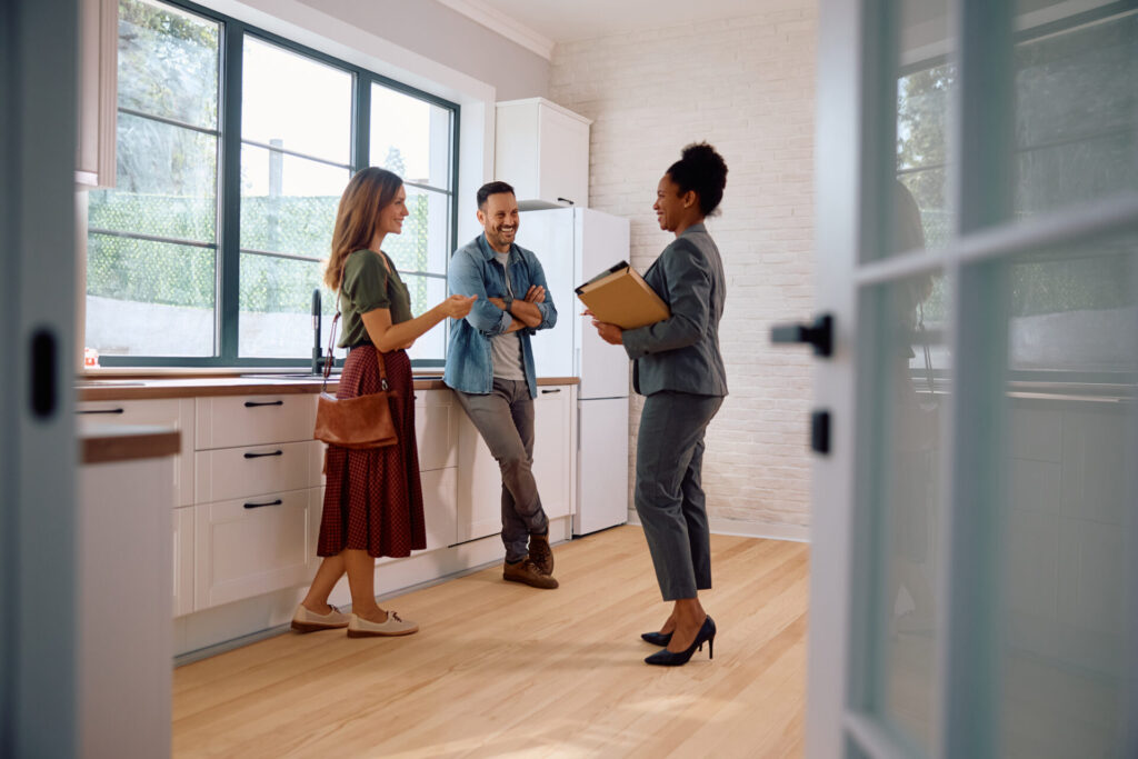 Estate agent discussing a property with buyers in a modern kitchen, reflecting rising home valuations in Consett following the 2026 Strategic Place Plan