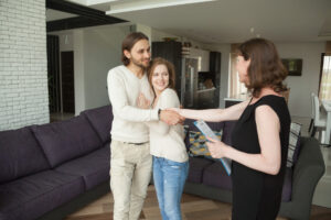 Landlords shaking hands with a letting agent inside a modern home, representing the move from let-only services to full property management in Camberwell