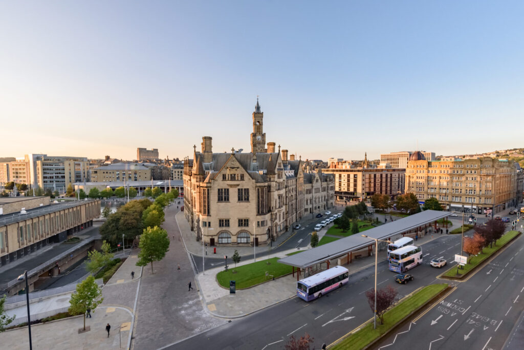 Aerial view of Bradford city centre featuring historic buildings and public transport, reflecting the local rental market and property sector.