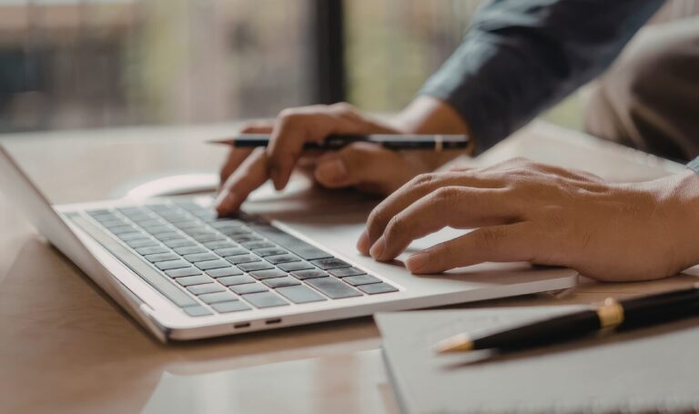 Landlord reviewing rental pricing on laptop with notes