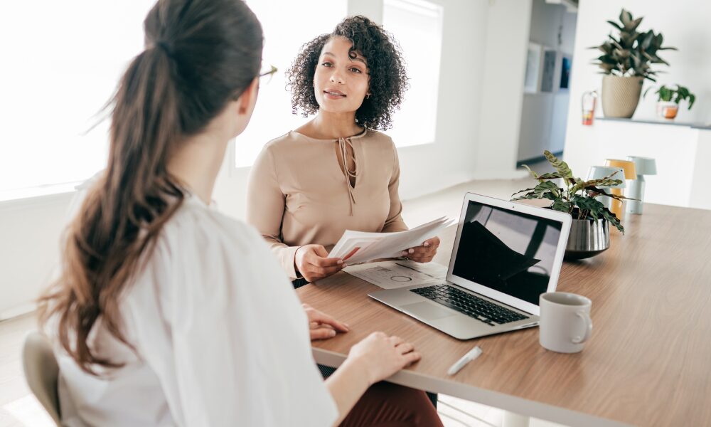 Letting agent discussing property investment documents with a client, representing growing demand for professional lets in Leeds city centre in 2026
