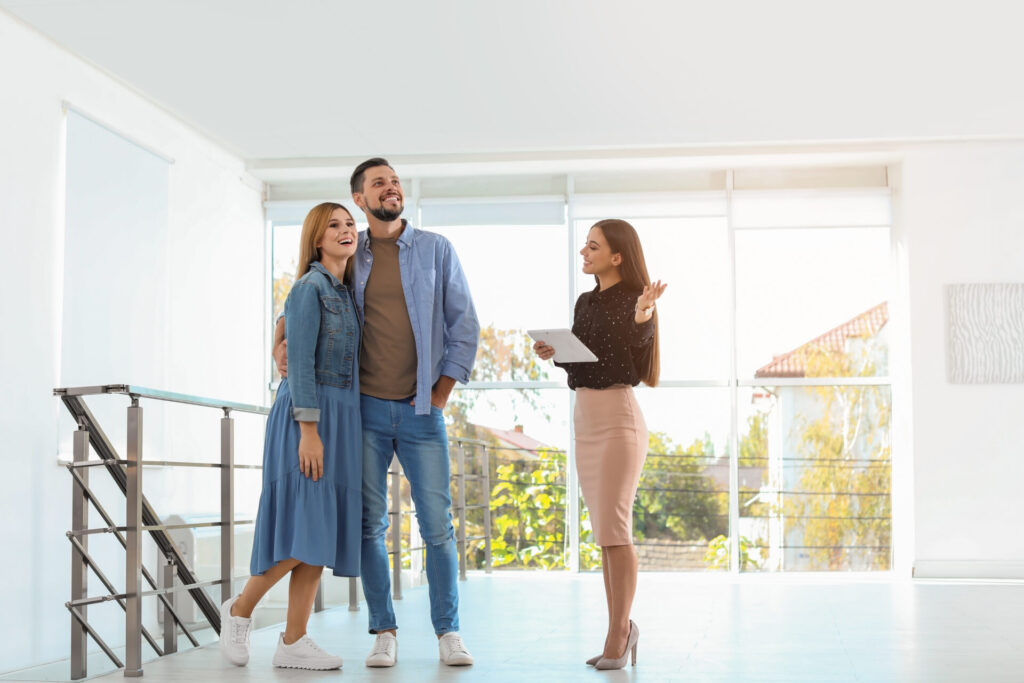 Estate agent showing a couple around a bright rental property during a viewing, reflecting landlord compliance and property upgrades in Harborne.