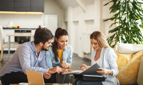 Estate agent discussing property documents with a couple during a buy-to-let consultation related to investment opportunities in Chesterfield.