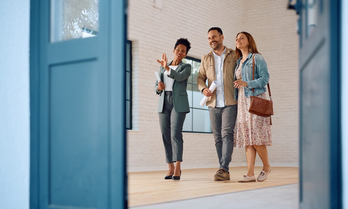 Estate agent guiding couple during property viewing in Annan