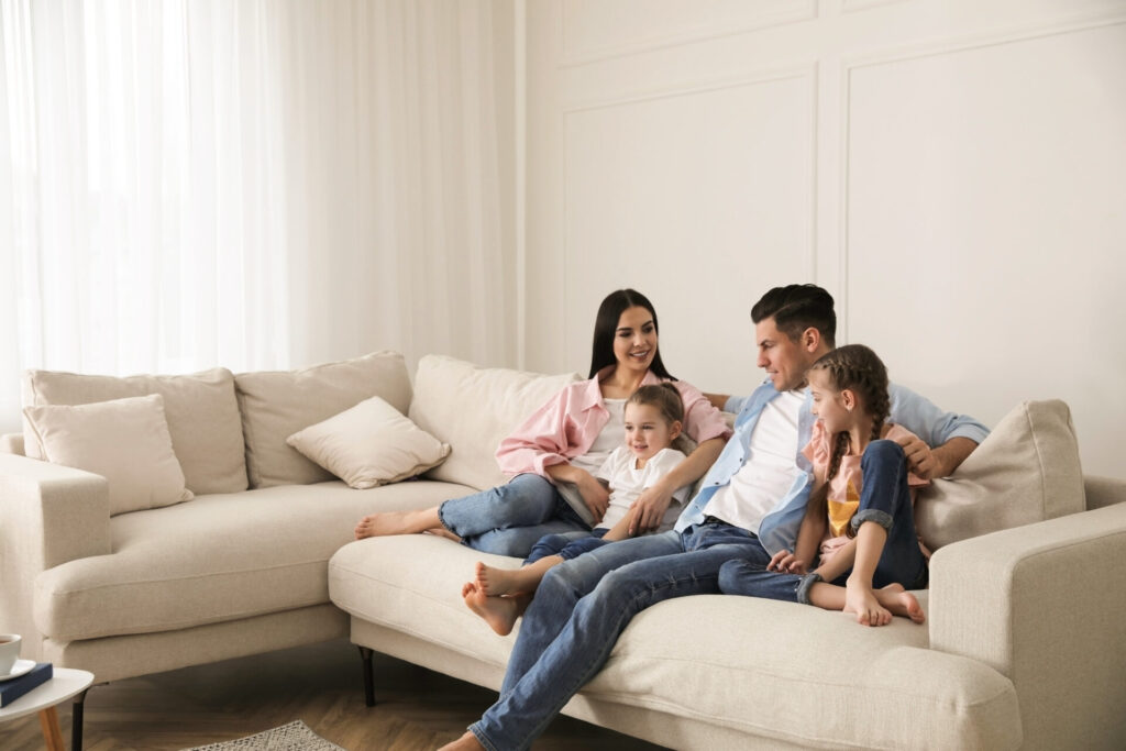 Family sitting together on a sofa in a bright and spacious living room
