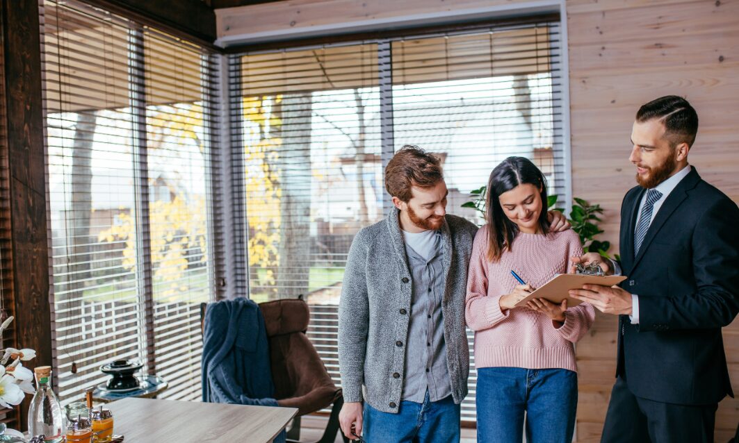 Estate agent discussing property agreement with couple in CF31 Bridgend