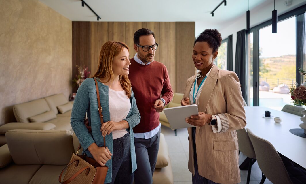 Estate agent showing property details to a couple in HG1 Harrogate