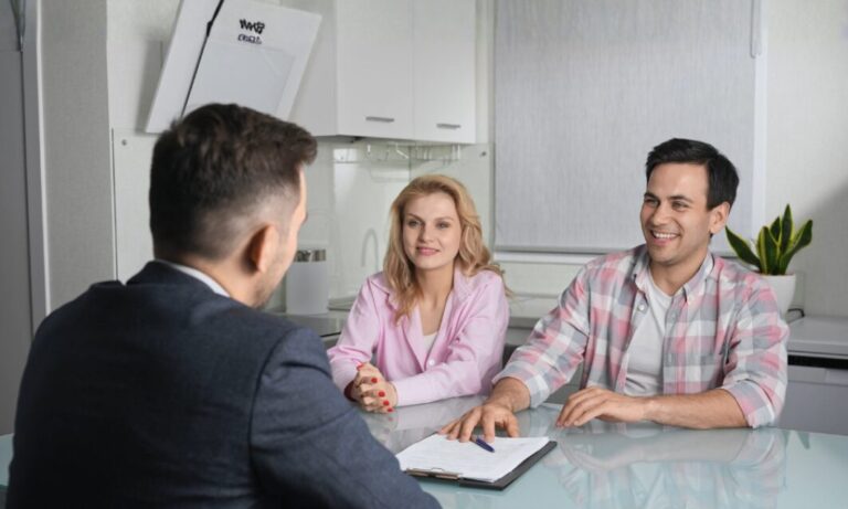 Estate agent discussing property details with couple in a home in Pencoed