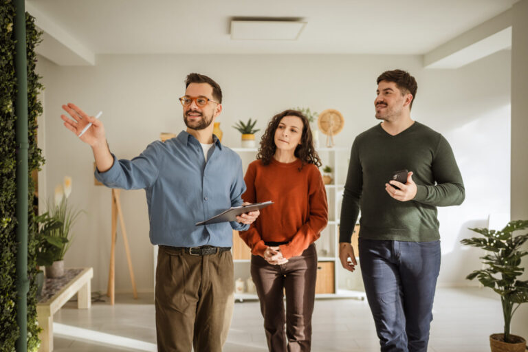 Estate agent showing a modern home to a couple looking to buy their first property in Tamworth