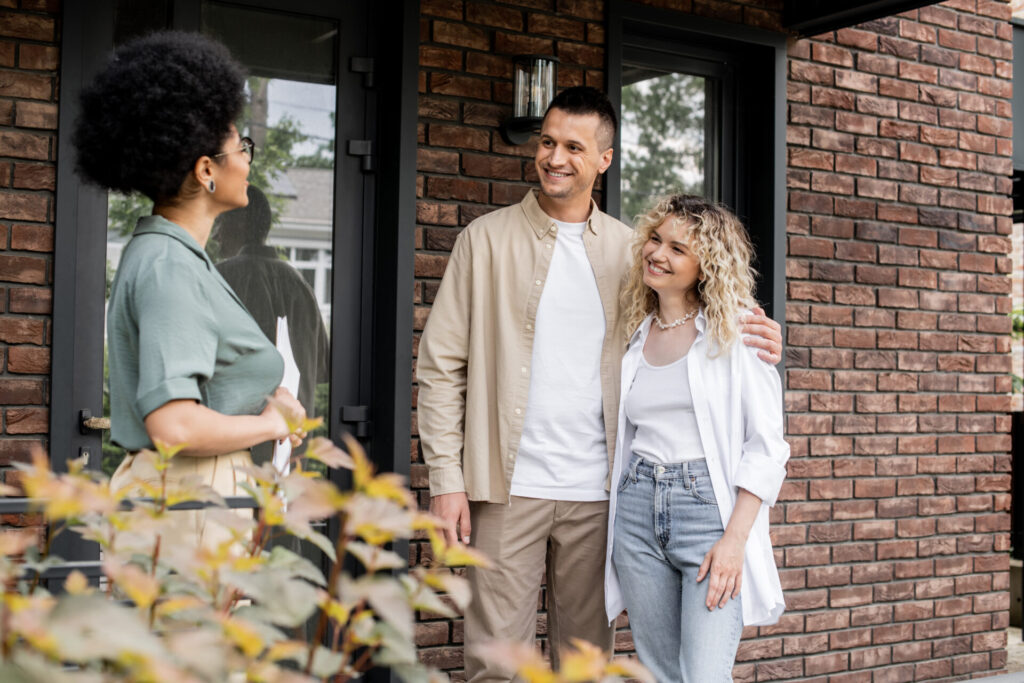 Estate agent showing a couple around a modern brick home during a viewing
