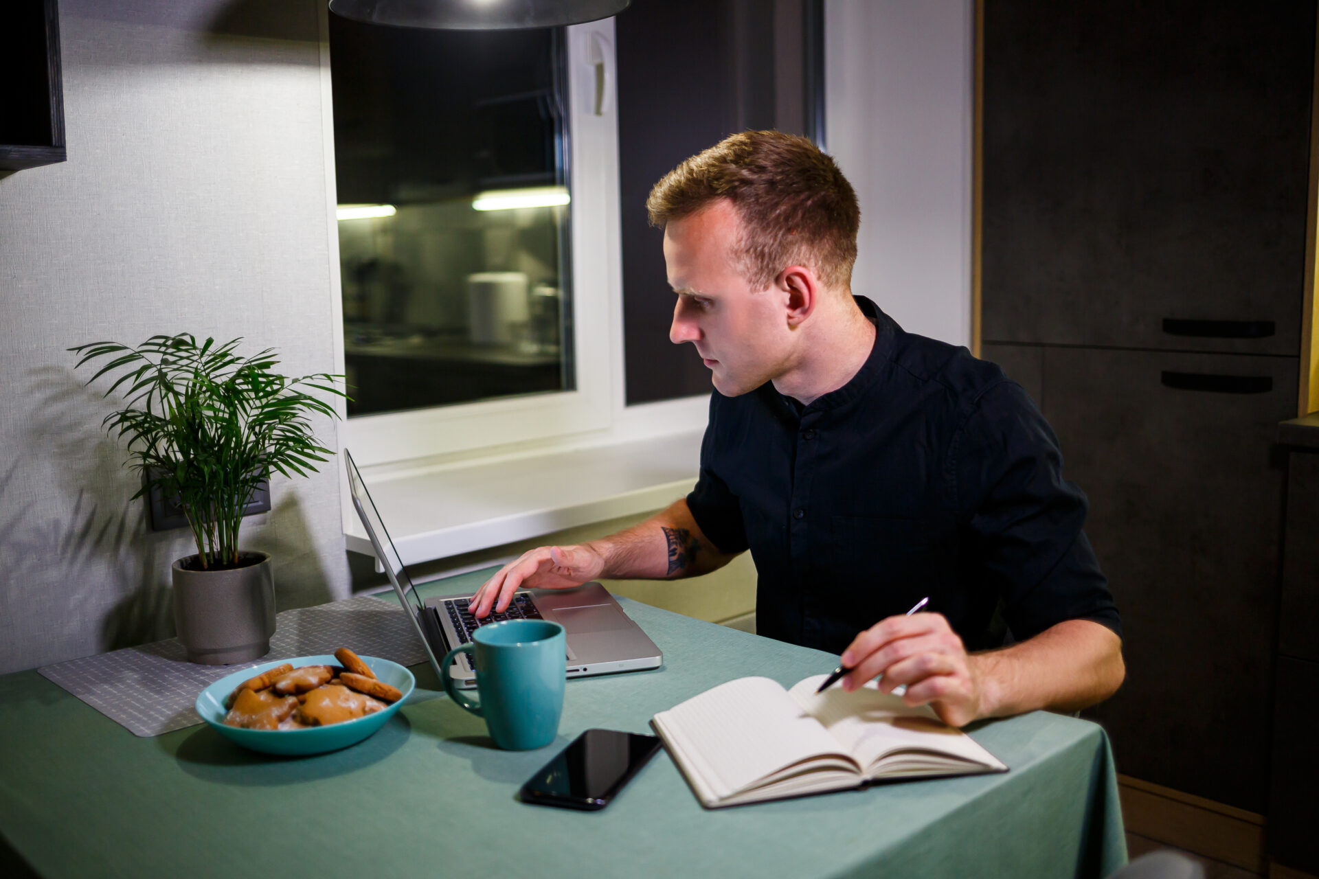 man working on laptop reviewing property research and housing market data at home