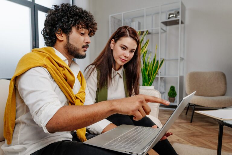 couple reviewing property listings on laptop while discussing home buying options in Skipton