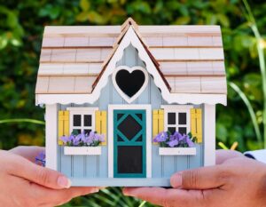 Hands holding a decorative house model symbolising home care and property maintenance in East Hertfordshire