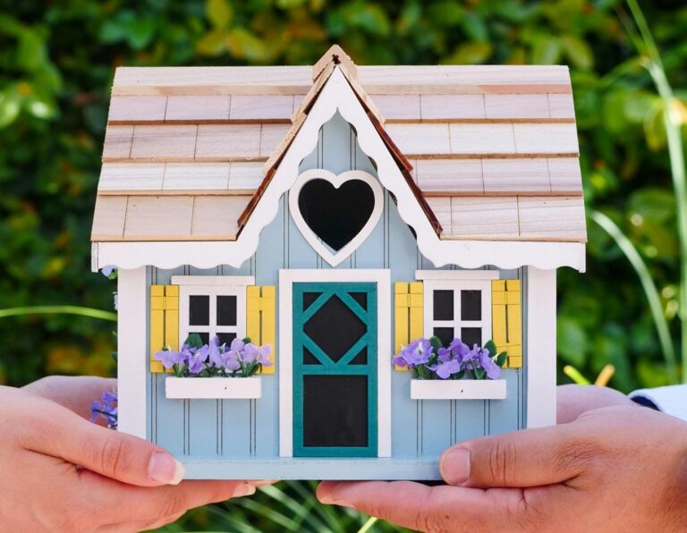 Hands holding a decorative house model symbolising home care and property maintenance in East Hertfordshire