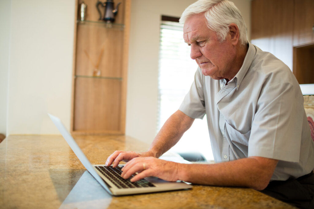 older man using laptop researching Leeds rental yield property investment opportunities