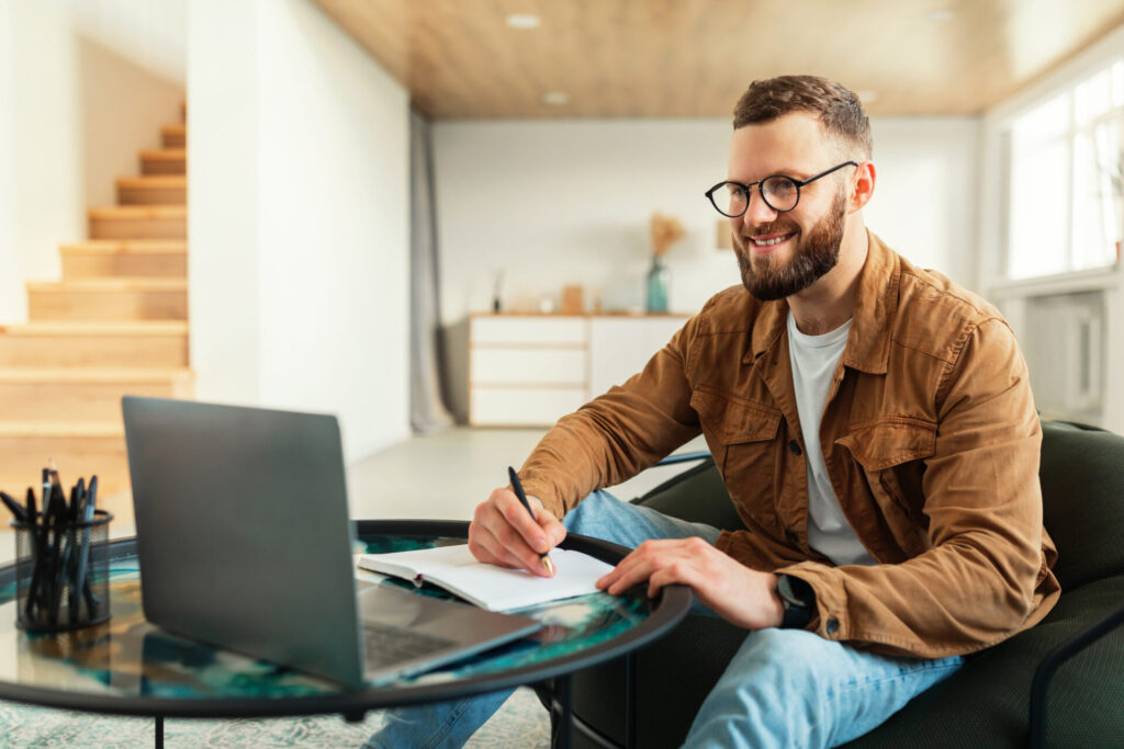 landlord reviewing rental property notes on laptop in modern home setting