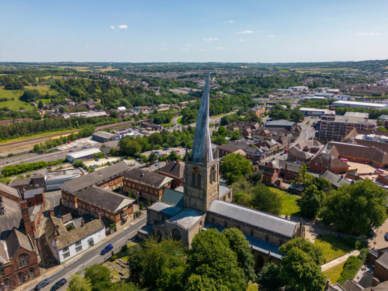 Drone view of Chesterfield town centre featuring the historic church spire, surrounding residential areas and commercial developments.
