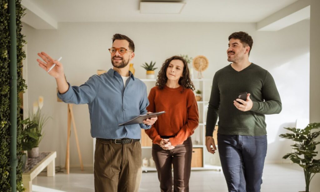 Estate agent showing a modern rental property to a couple during a home viewing in Exeter.