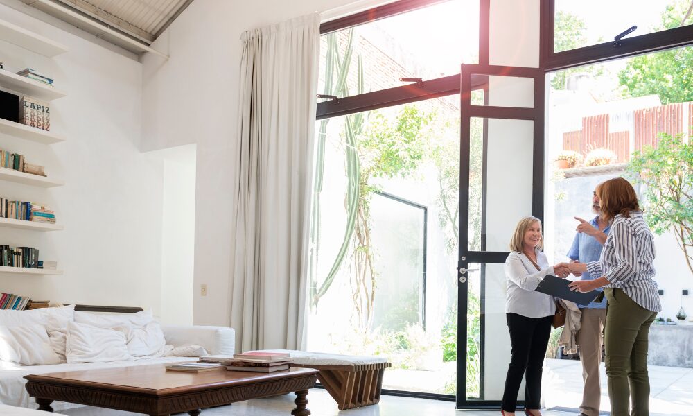 Landlord greeting prospective tenants during a property viewing in a bright modern home in Harrogate.