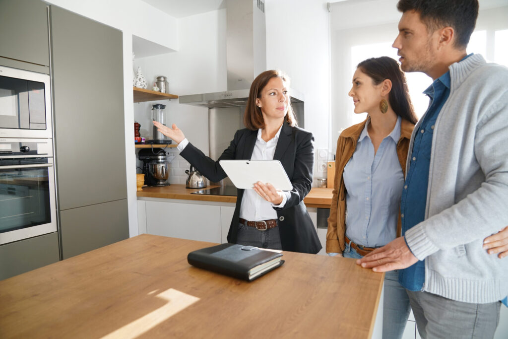 Estate agent discussing property compliance and rental regulations with landlords during a property viewing.