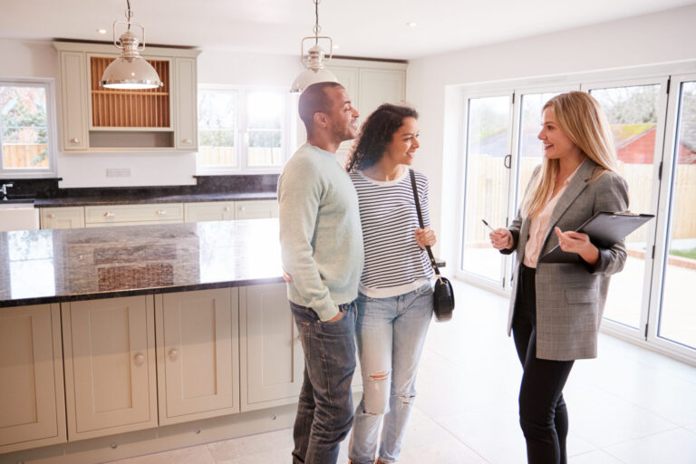 Landlord showing a modern kitchen and open-plan rental property to prospective tenants in Kendal.
