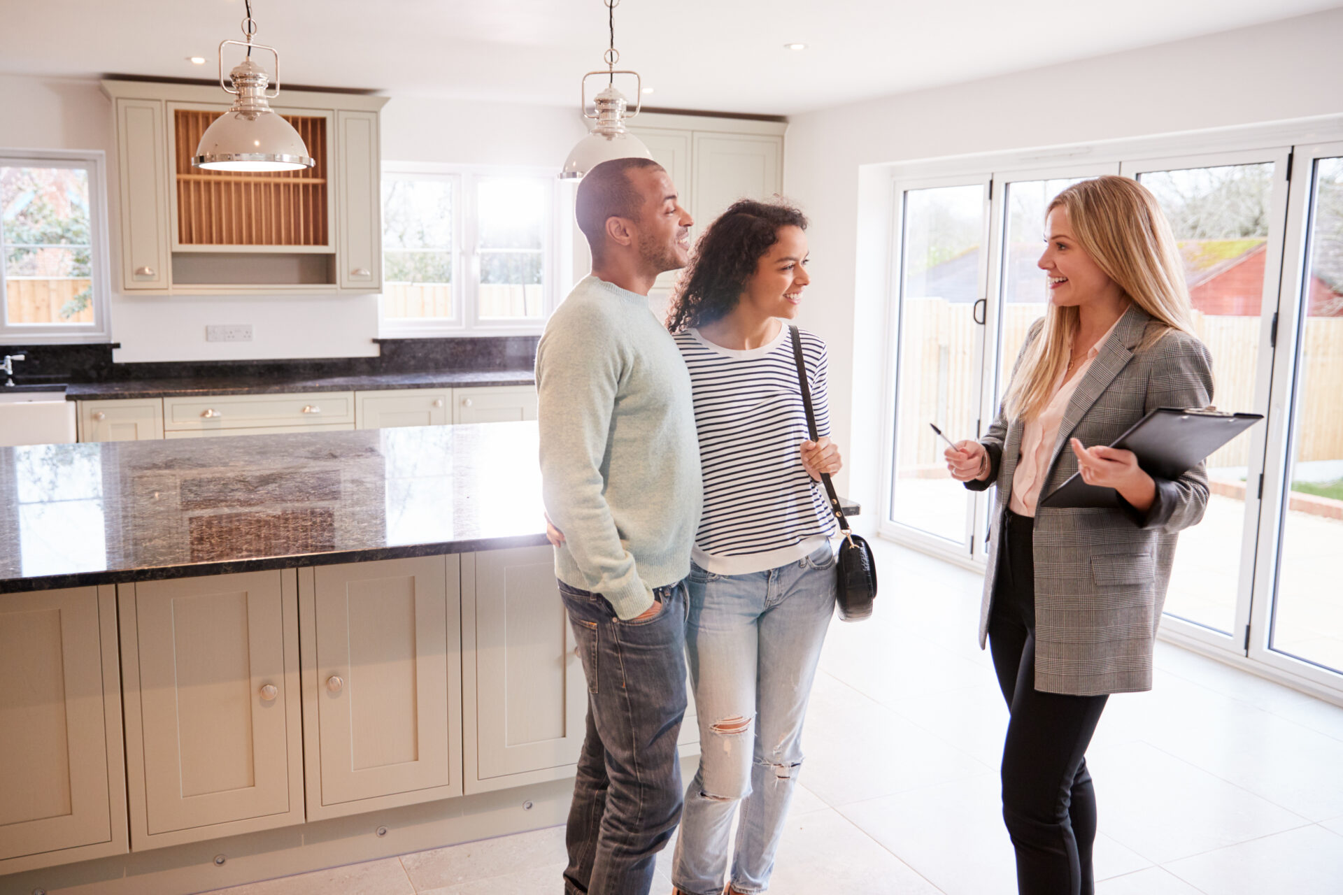 Landlord showing a modern kitchen and open-plan rental property to prospective tenants in Kendal.