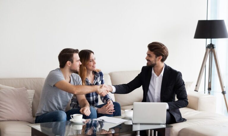 Landlord shaking hands with tenants during a rental property meeting in a modern Leeds apartment.