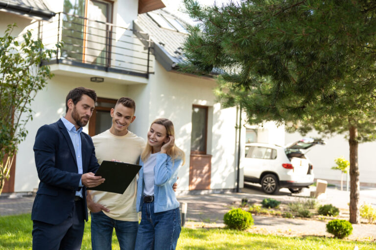 Estate agent discussing rental property information with a young couple outside a modern Solihull home.