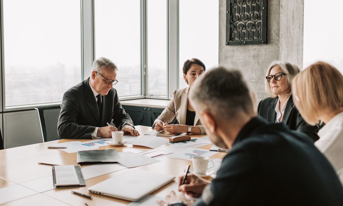 Landlords and property professionals discussing rental management costs and investment decisions during a business meeting.