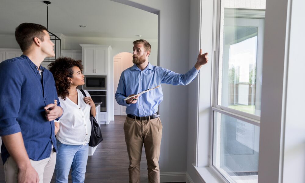 Property manager discussing rental property responsibilities and compliance requirements with prospective landlords during a viewing.