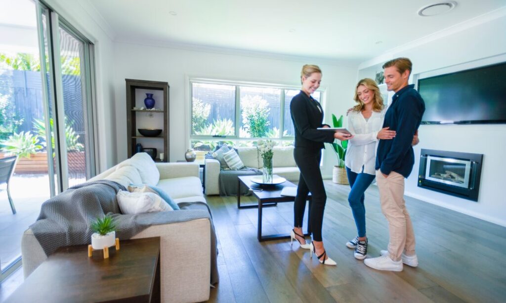 Estate agent showing a couple around a bright modern home, representing Bradford buy-to-let areas and rental yield opportunities.