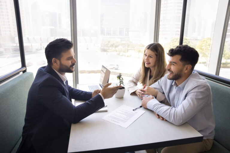 Property adviser discussing rental documents with a couple, representing Gravesend rental yields and landlord investment opportunities.